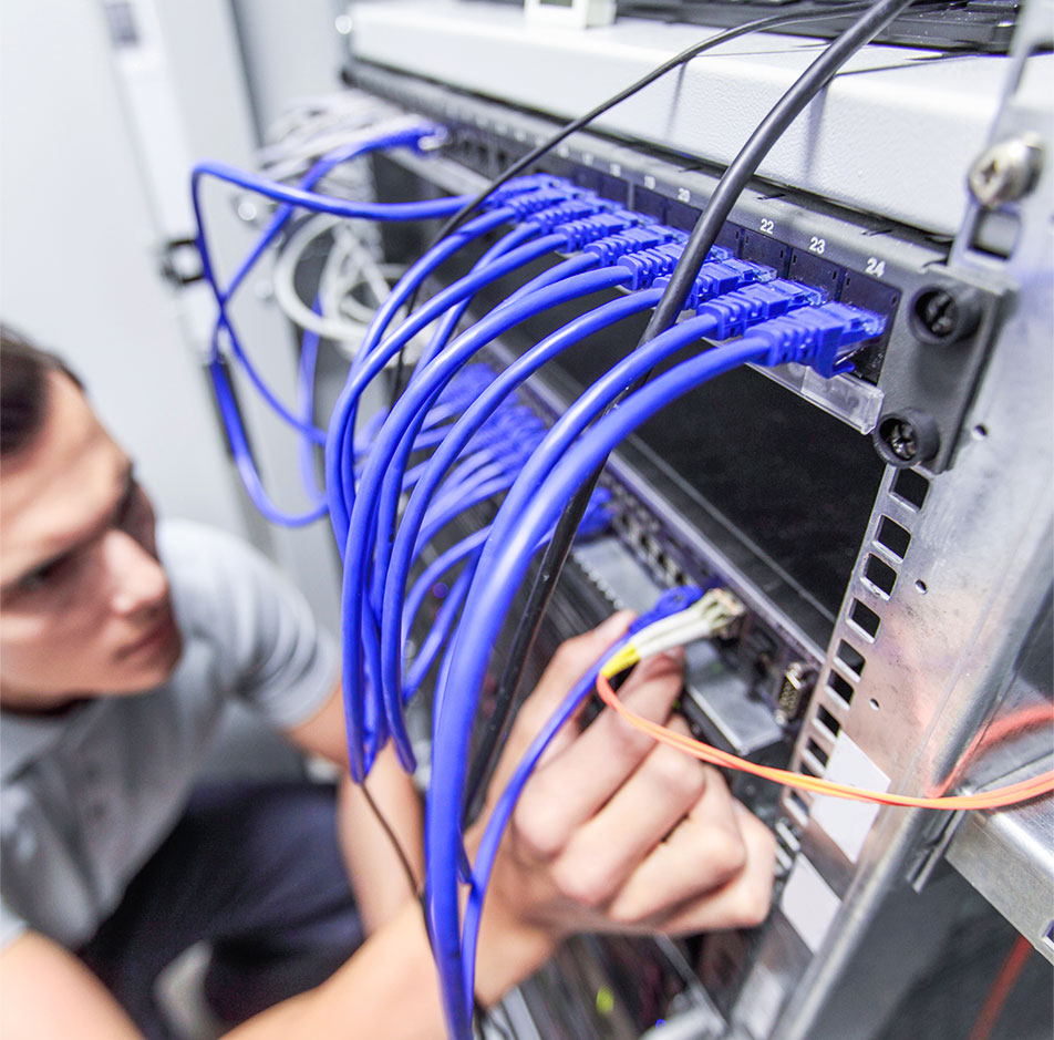 Técnico conectando cableado de red en un rack de comunicaciones